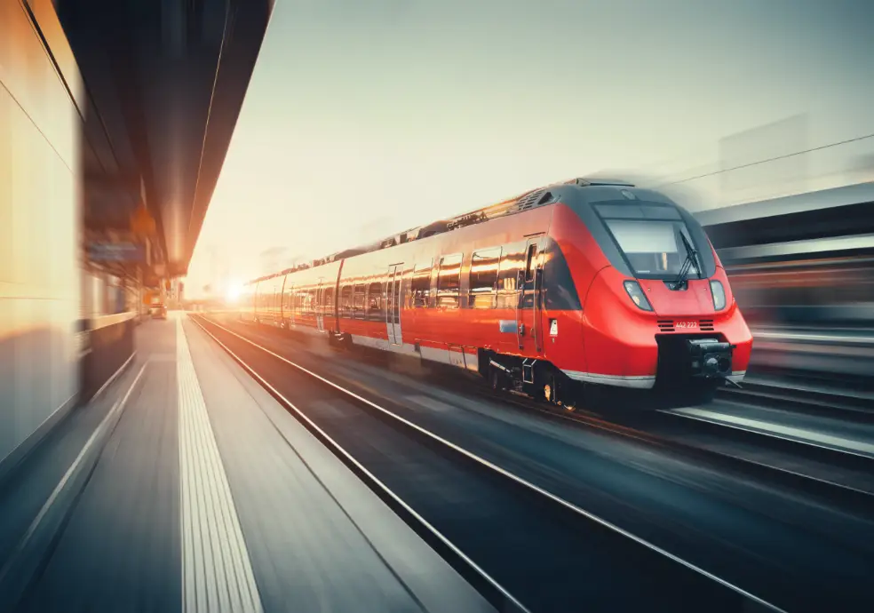 Fahrtkostenzuschuss-bahn-und-bus Zug der mit hoher Geschwindigkeit durch einen Bahnhof fährt.