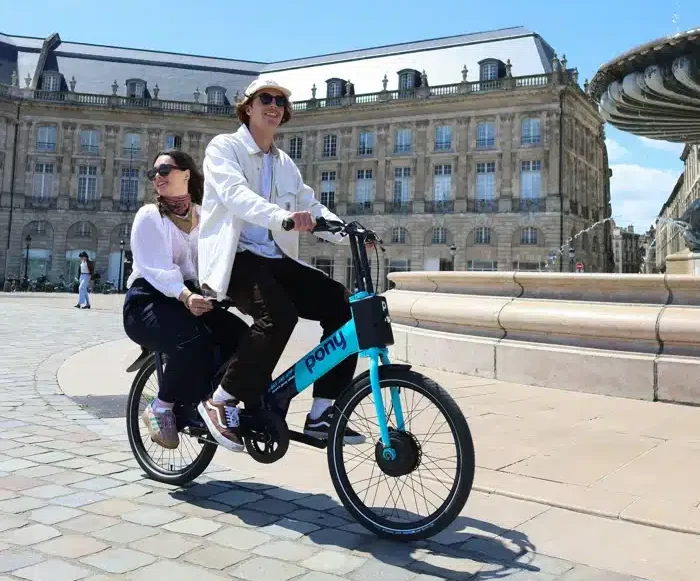 Mobilitätsbudget: ein Pärchen fährt auf einem E-Rad durch die Innenstadt
