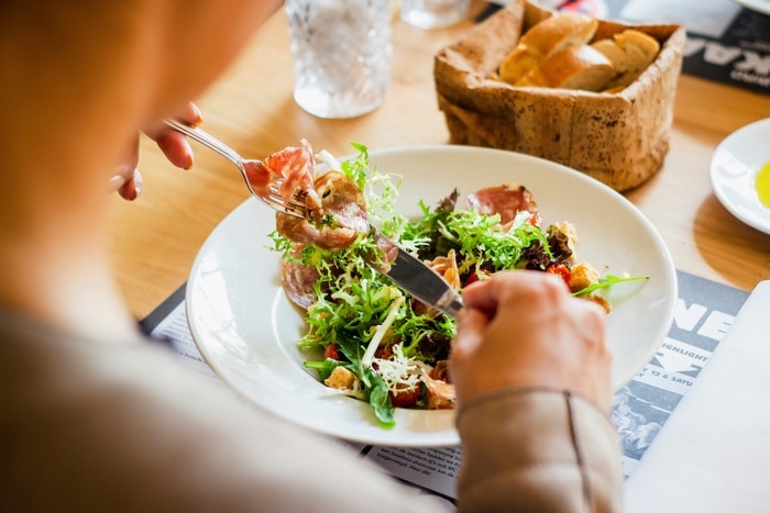 Employer Branding durch Mitarbeiterverpflegung stärken: Mitarbeiter mit einem frischen Salat beim Lunch.