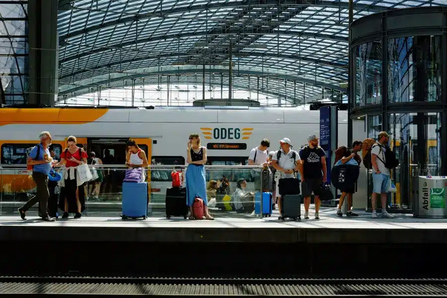 Zwei Frauen und ein Mann in einem Zug im warmen Sonnenlicht.