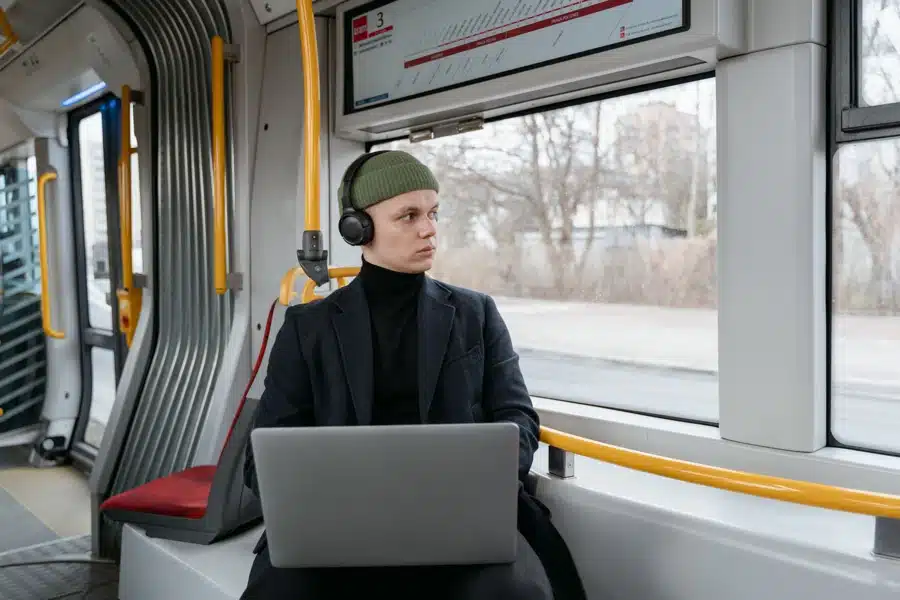 Fahrgast mit Smartphone am Bahnsteig vor einem Regionalzug