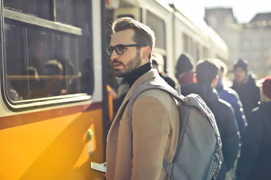 Fahrgast mit Smartphone am Bahnsteig vor einem Regionalzug