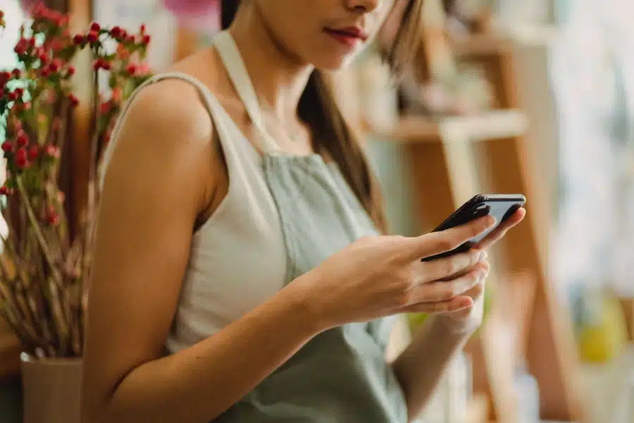 Mitarbeitende im Service nutzen ein Smartphone – Sachbezug für Minijobber